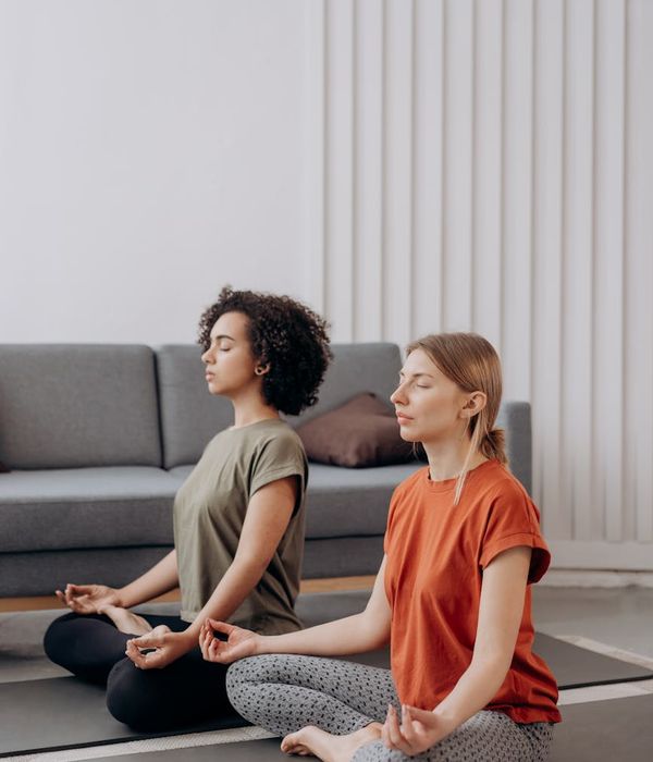 Woman in a calm yoga pose in a minimalist room.